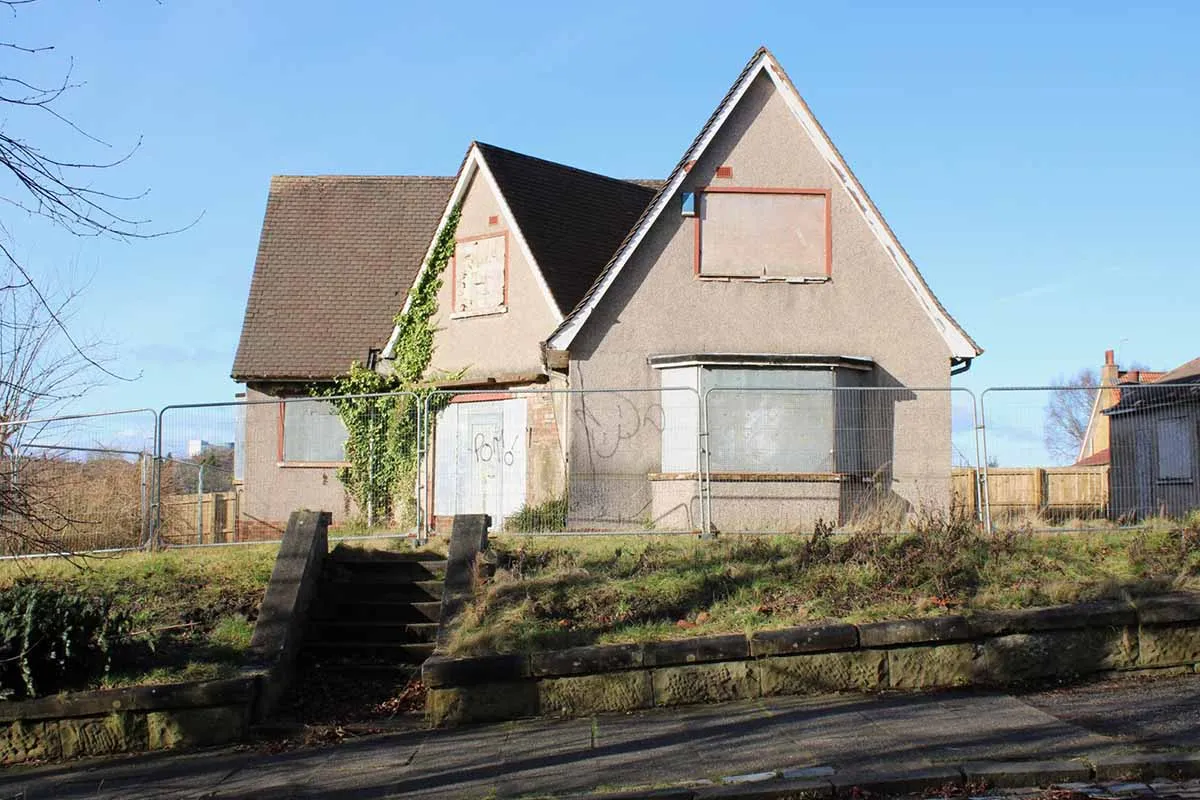 Photo showing a repossessed house for sale which has been boarded up.