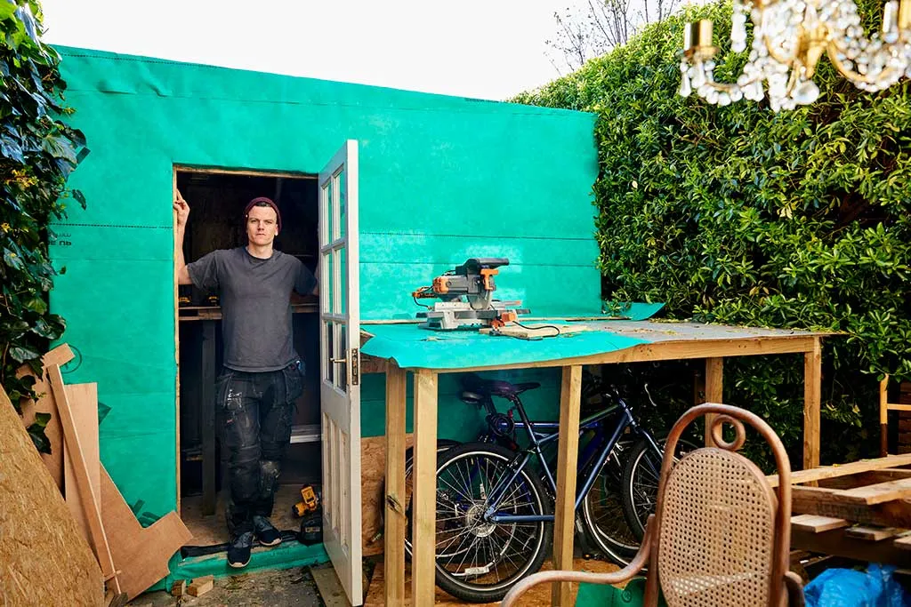 Image of a man building a garden shed without planning permission in his garden.