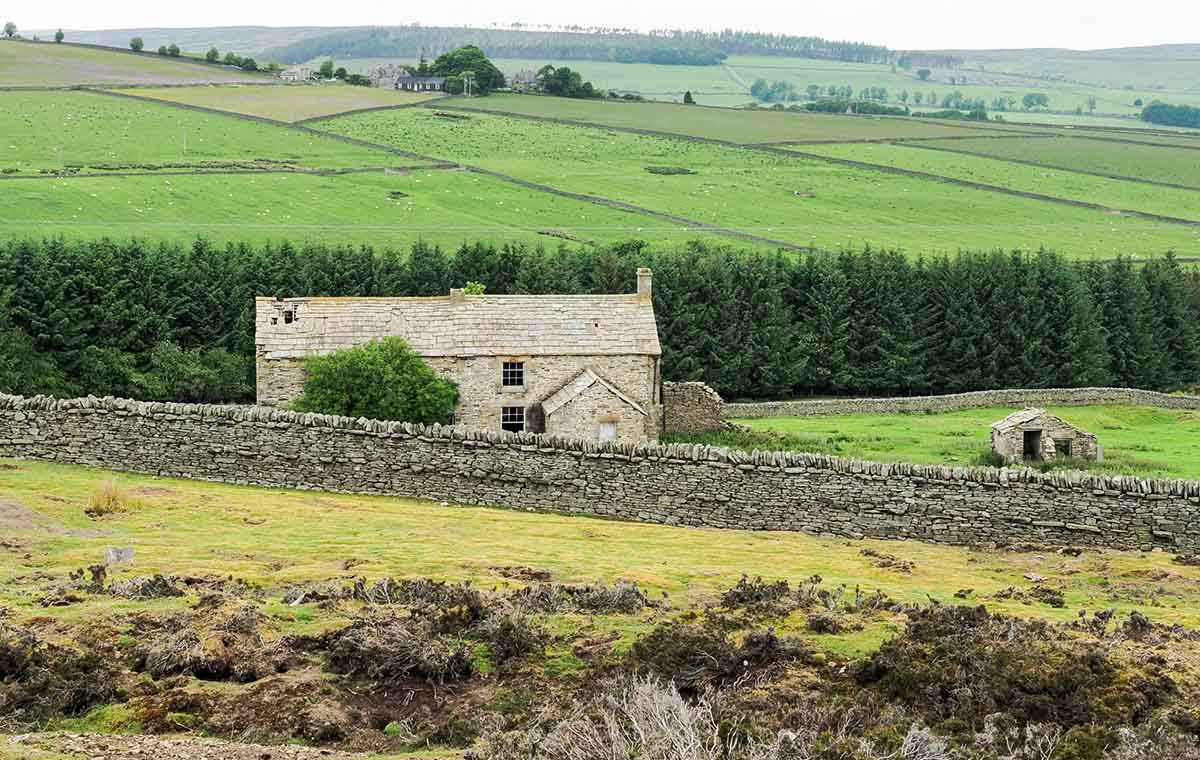 Photo of an abandoned house for sale with a slate roof.